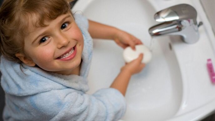 a criança lava as mãos com sabonete para evitar vermes